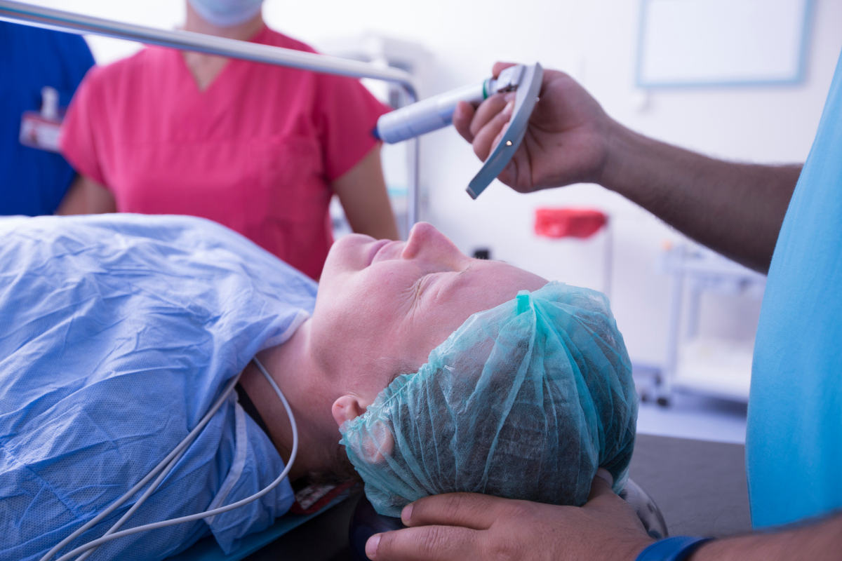 Profissional prestes a fazer intubação orotraqueal em paciente