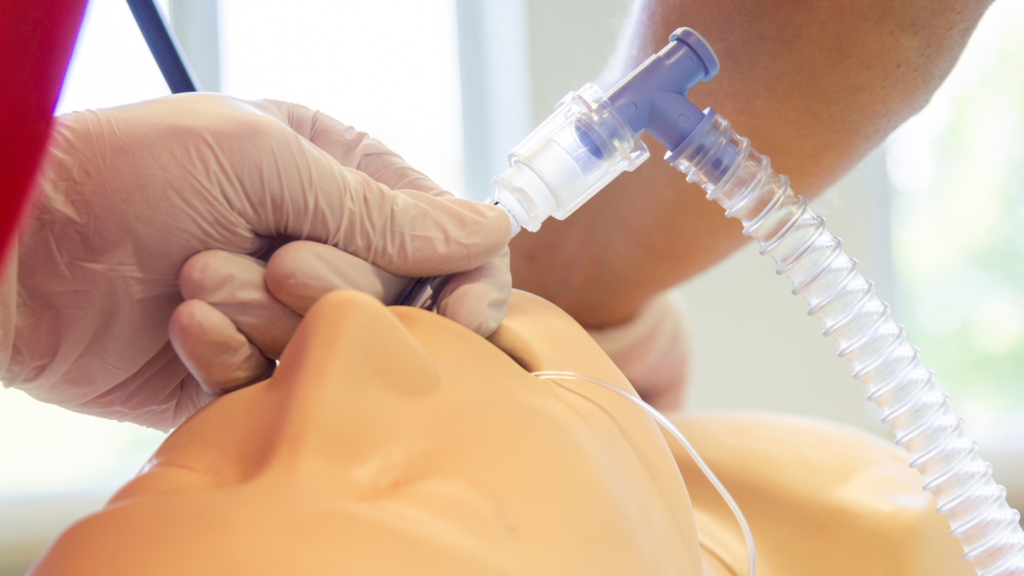 Médico realizando intubação orotraqueal em manequim