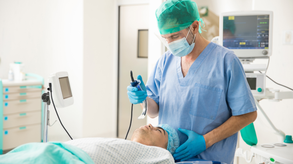 Médico realizando intubação orotraqueal em paciente
